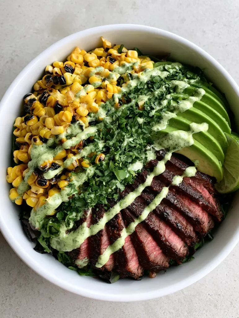 Whole30 Steak and Avocado Bowl with Charred Sweet Corn 1 Close up of the zig-zag cilantro cream sauce over a Whole30 Steak and Avocado Bowl.