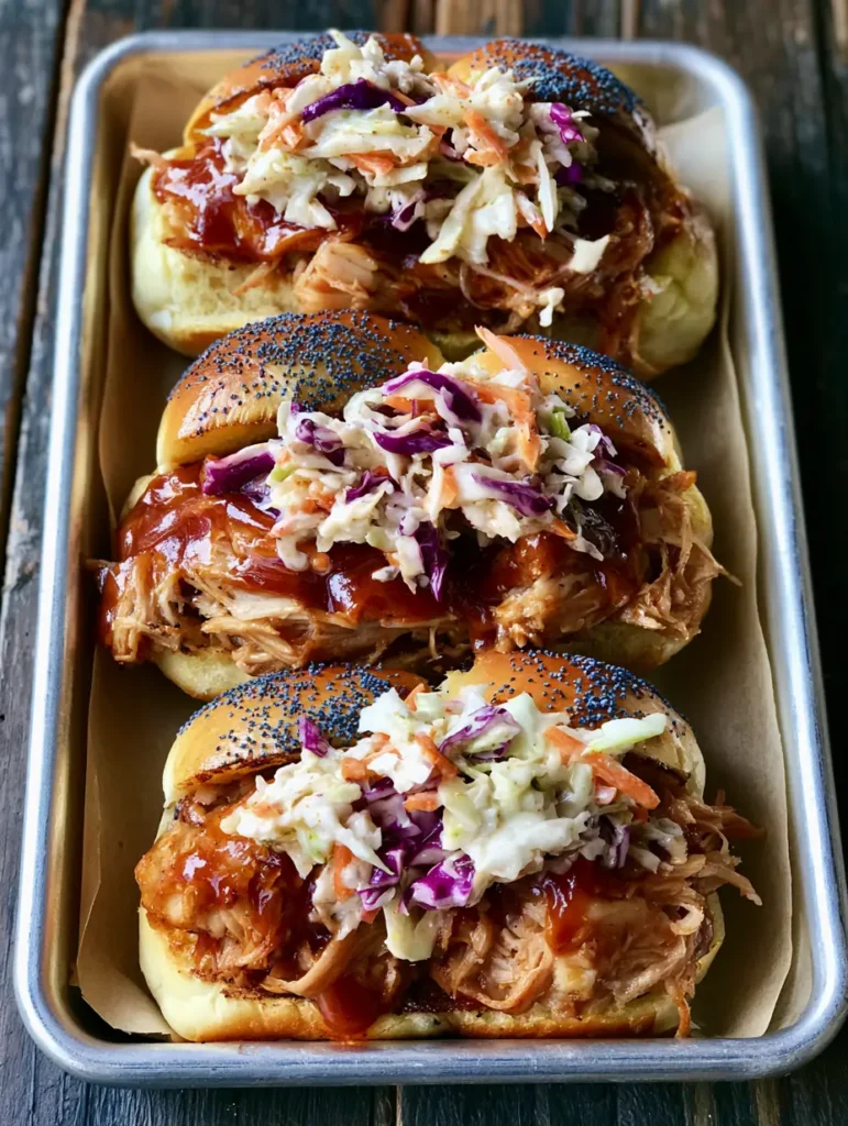 Smartphone handheld photo of three Pulled Pork Sliders, showcasing the layers of shredded meat and creamy purple and green cabbage slaw.