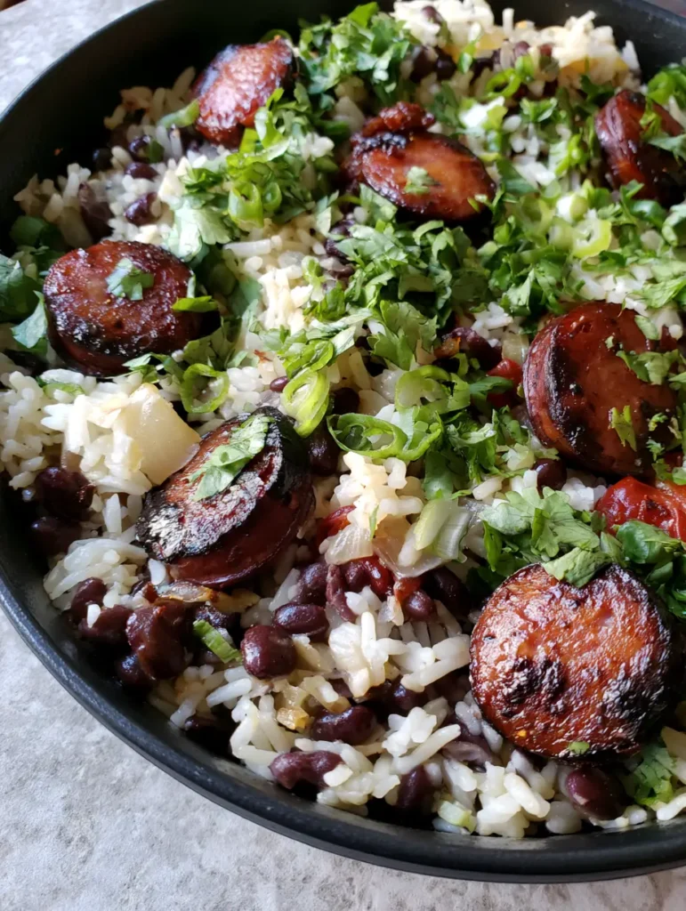 A skillet of One-Pot Black Beans and Rice garnished with fresh cilantro and sliced green onions.