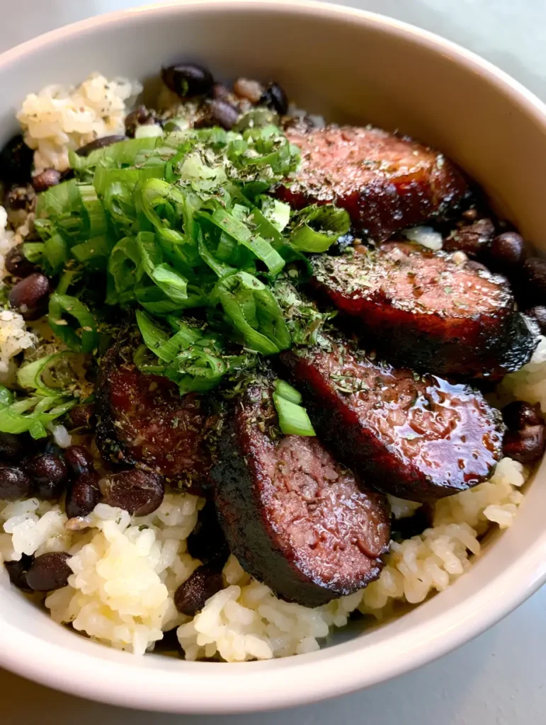 Black Beans and Rice with Sausage: The Ultimate Smoky Weeknight Comfort 1 Wide shot of a shallow ceramic bowl with Black Beans and Rice with Sausage, showing the light oil sheen and herb garnish.