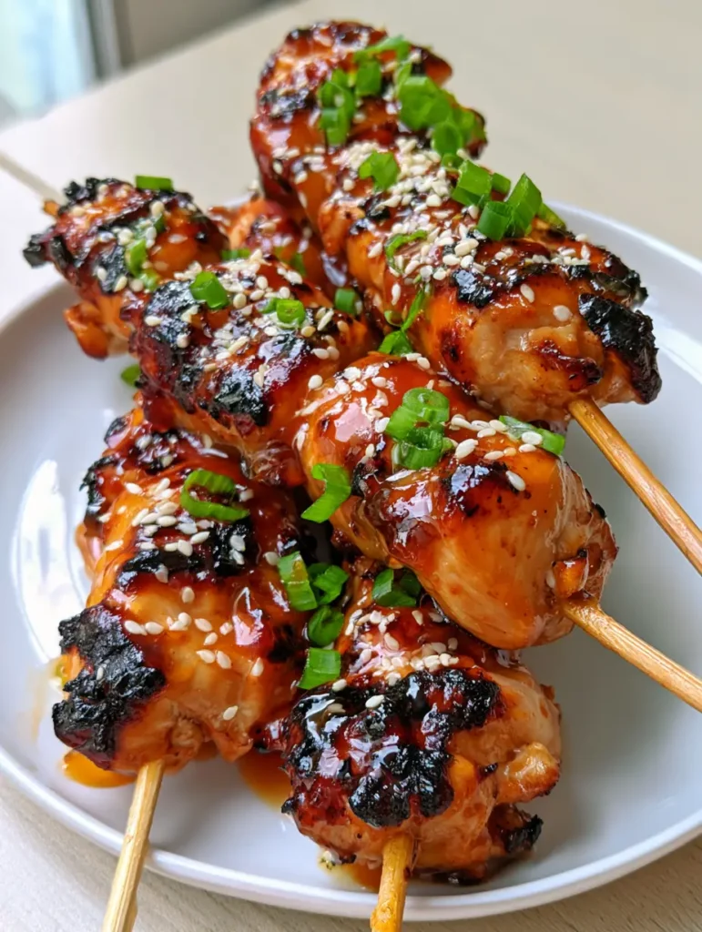 Honey Garlic Chicken Skewers: The Ultimate Recipe for Sticky, Charred Perfection 1 Stacked Honey Garlic Chicken Skewers showing deep charred grill marks and vibrant scallion garnish.