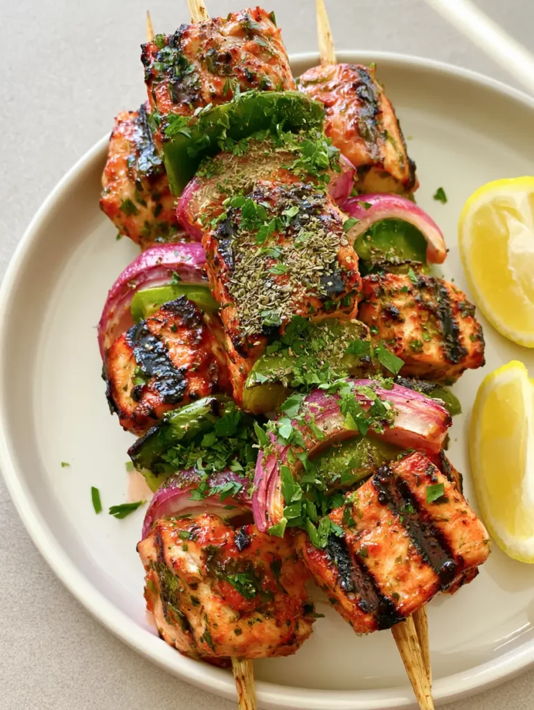 Juicy cubes of chicken on skewers with oregano and parsley garnish. (Greek Marinated Chicken Kabobs)